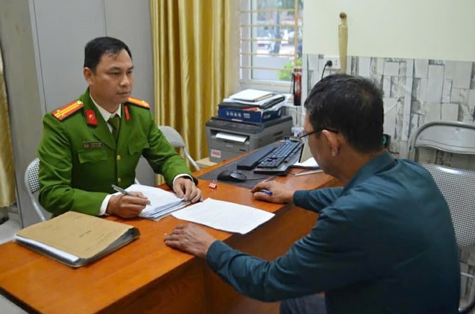 Nghi can Sơn (góc phải) làm việc với cảnh sát. Ảnh: Báo Nghệ An