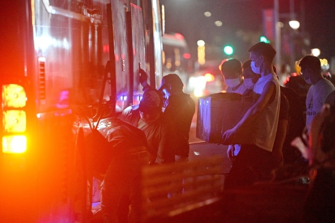 Dòng người mang theo đồ đạc cá nhân lên xe khách khi rời khỏi một khu phức hợp bị nghi ngờ là trung tâm lừa đảo ở Sihanoukville ngày 14/1. Ảnh: AFP