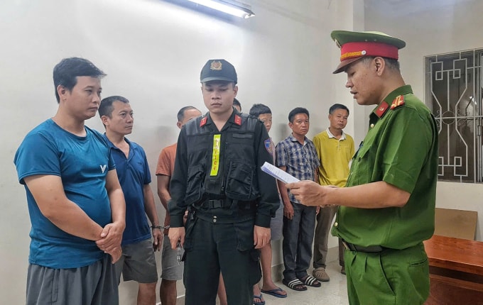 Cảnh sát đọc lệnh khởi tố với nhiều nghi can. Ảnh: Công an TP HCM