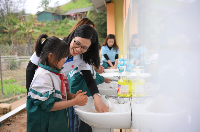 Đại diện Bảo hiểm GIC cùng rửa tay với học sinh ở nhà vệ sinh mới. Ảnh: Home Credit Việt Nam