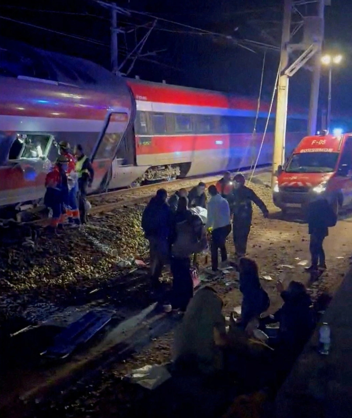 Nhân viên cứu hộ đưa thi thể nạn nhân ra khỏi các đoàn tàu gặp nạn. (Nguồn: Reuters)