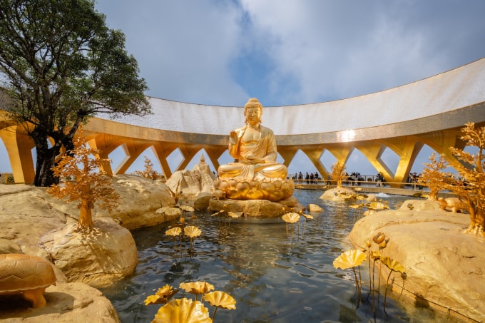 Tượng Đức Phật Câu Na Hàm Mâu Ni ngồi tướng kiết già (hay còn gọi là liên hoa tọa) giữa hồ sen vàng. Ảnh: Sun Group