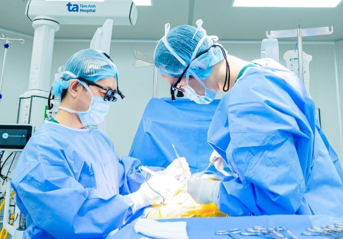 Bác sĩ Dũng (trái) cùng êkíp phẫu thuật bóc nội mạc động mạch cảnh cho bệnh nhân. Ảnh: Hạ Vũ