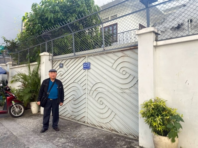 Ông Huỳnh Larry Hưng đứng trước căn biệt thự mua 20 năm trước, chờ cơ quan thi hành án cưỡng chế bàn giao cho mình, nhưng bất ngờ buổi làm việc bị tạm hoãn, ngày 18/12. Ảnh: Hải Duyên