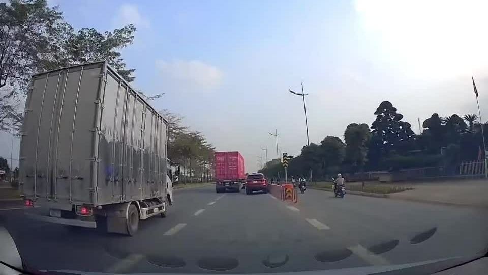 Xe container chuyển làn hất xe con vào dải phân cách