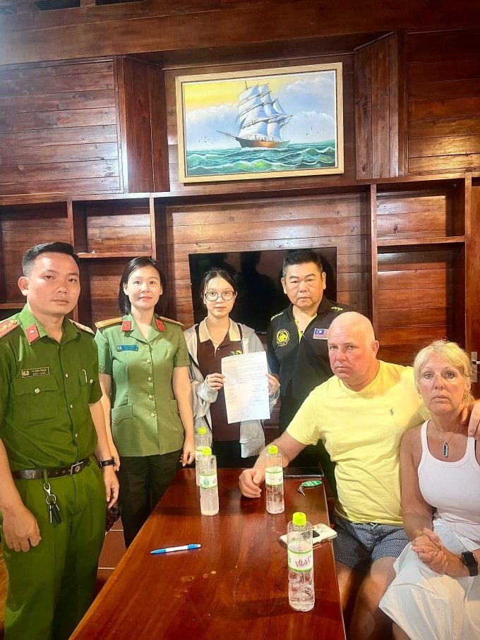 Vợ chồng du khách Anh (phải) chụp ảnh cùng lực lượng chức năng sau khi nhận lại số tiền. Ảnh: UBND đặc khu Phú Quốc