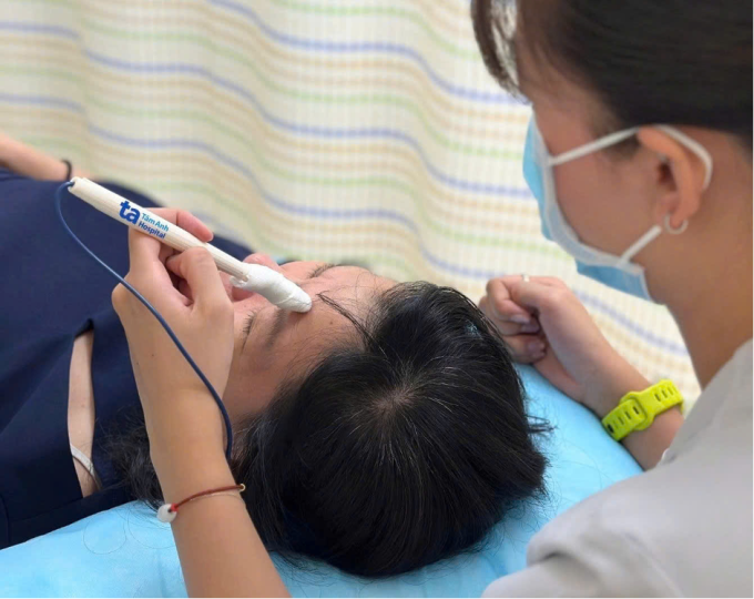 Kỹ thuật viên điện xung kích thích cơ mặt cho bà Thoa, duy trì trương lực cơ và phục hồi vận động. Ảnh: Bệnh viện Đa khoa Tâm Anh