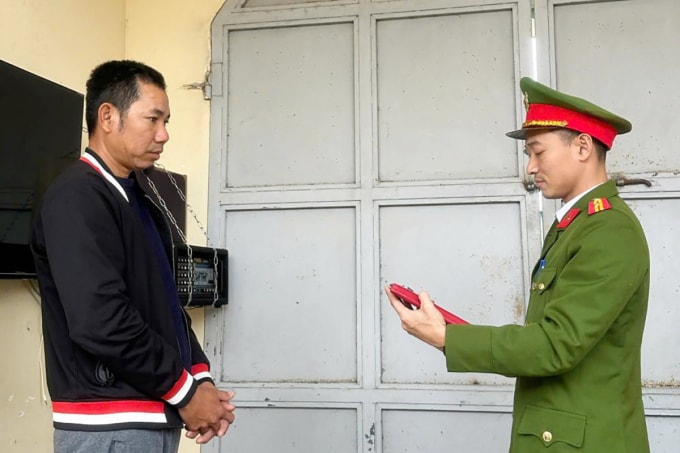 Nghi can Lưu (góc trái) nghe cảnh sát đọc lệnh khởi tố. Ảnh: Công an cung cấp