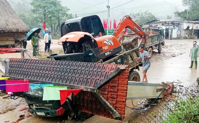 Xe tải chở xe múc làm sập cổng chào, 2 người trong cabin tử vong- Ảnh 1.