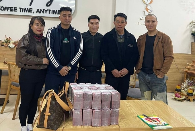 Anh Nguyễn Văn Huấn (đứng giữa) trao lại một tỷ tiền mặt cho vợ chồng chị Vân tại xã Tiên Lục, tỉnh Bắc Ninh, chiều 23/1. Ảnh: Nhân vật cung cấp