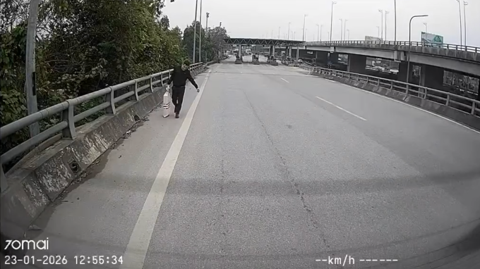 Anh Nguyễn Văn Huấn nhặt bao tải trắng rơi trên cao tốc hướng Ninh Bình - Hà Nội, đoạn qua trạm thu phí Liêm Tuyền, trưa 23/1. Ảnh: Nhân vật cung cấp