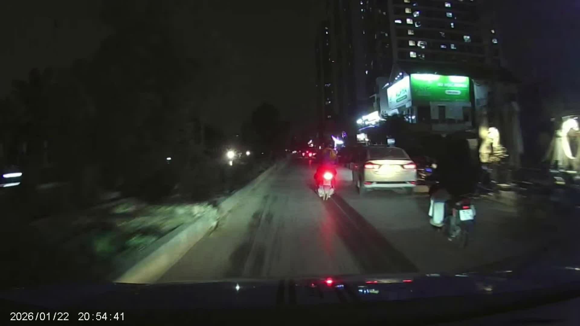 Hai người đi xe máy ngã vào đầu ôtô