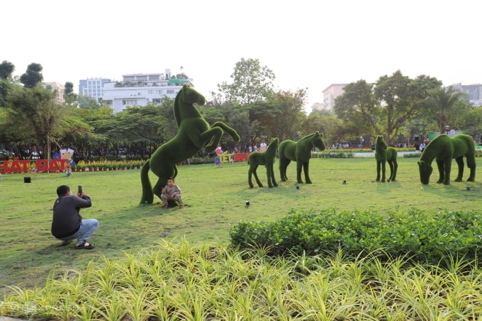 Người dân chụp ảnh bên linh vật ngựa ở công viên, chiều 25/1. Ảnh: Lê Tuyết