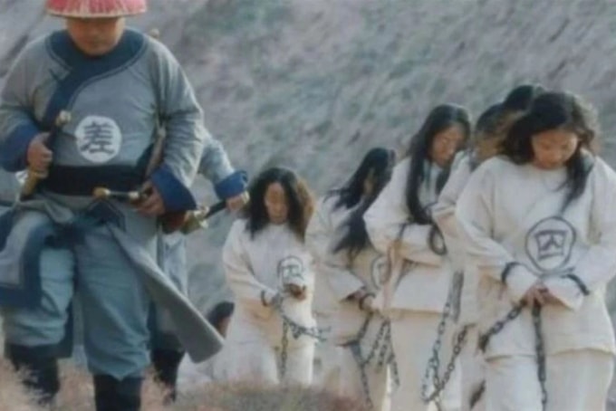 Du khách mặc áo in chữ tù nhân, đeo xiềng xích mang tính biểu trưng. Ảnh: SCMP