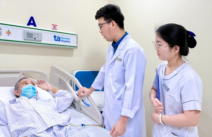 Bác sĩ hỏi thăm tình hình sức khỏe ông Quang sau phẫu thuật. Ảnh: Bệnh viện cung cấp