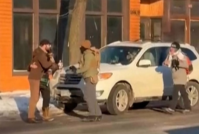 Người mặc áo khoác nâu bám vào