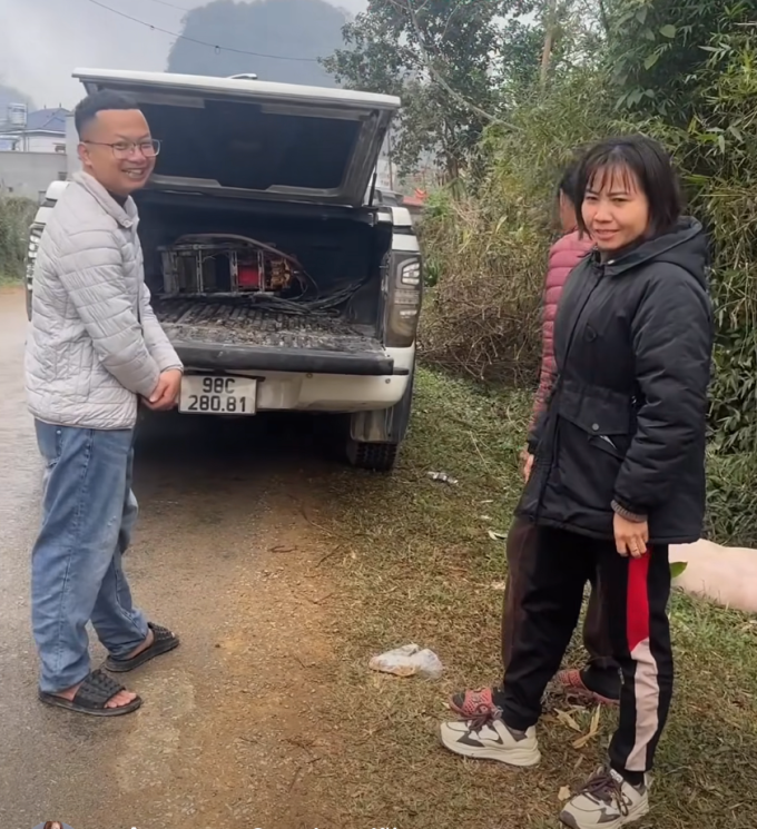 Chị Lương Ngâm (phải) trao trả lại con lợn nhảy khỏi thũng xe bán tải cho anh Thành Chung (trái) tại thôn Nam Hương 1, xã Vũ Lăng, trưa 24/1. Ảnh: Lương Ngâm