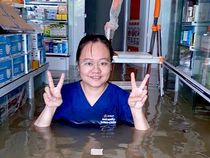 Dược sĩ lội nước để chuyển thuốc lên cao tại vùng lũ. Ảnh: Long Châu