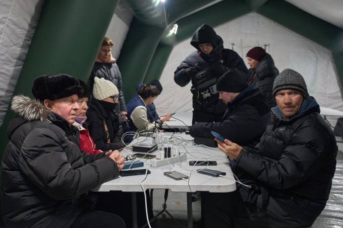 Người dân Kiev sưởi ấm và sạc điện thoại trong một lều trú ẩn khẩn cấp dựng ngoài khu chung cư tại Kiev ngày 21/1. Ảnh: AP
