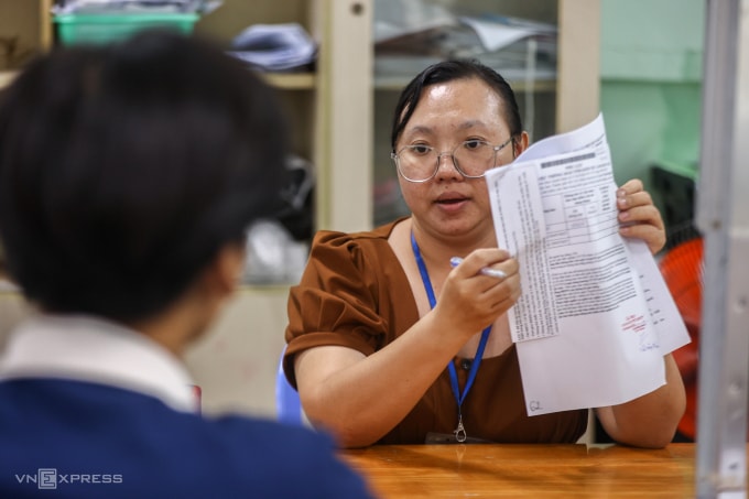 Nhân viên tiếp nhận hồ sơ nhận trợ cấp thất nghiệp tại Trung tâm dịch vụ việc làm TP HCM. Ảnh: Quỳnh Trần