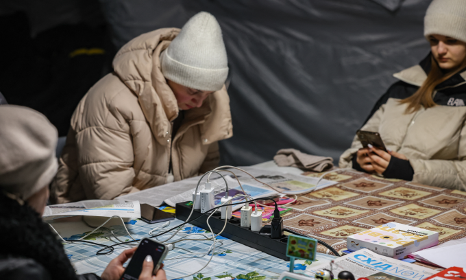 Người dân Ukraine trú ẩn bên trong điểm sưởi ấm di động tại Chernihiv hôm 24/1. Ảnh: AFP