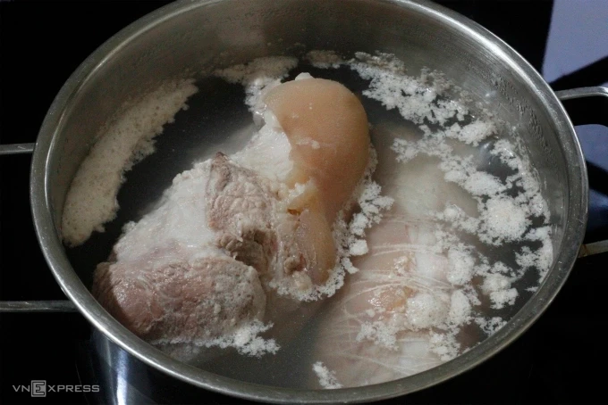 Luộc thịt từ nước lạnh vài phút đầu loại bỏ tạp chất. Ảnh: Bùi Thủy