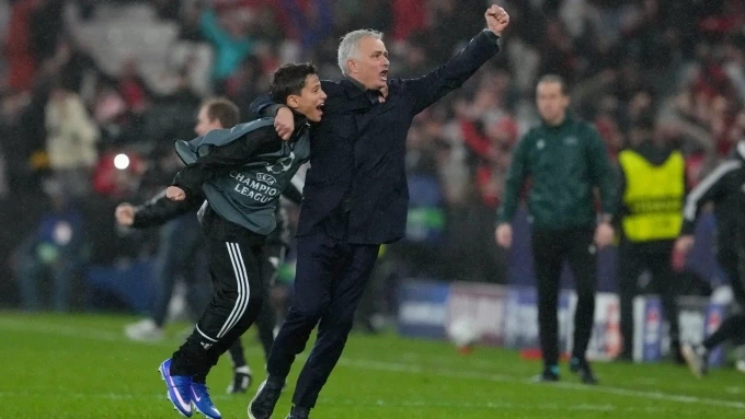 Mourinho ăn mừng cùng một cậu bé nhặt bóng sau khi Trubin ghi bàn. Ảnh: AP