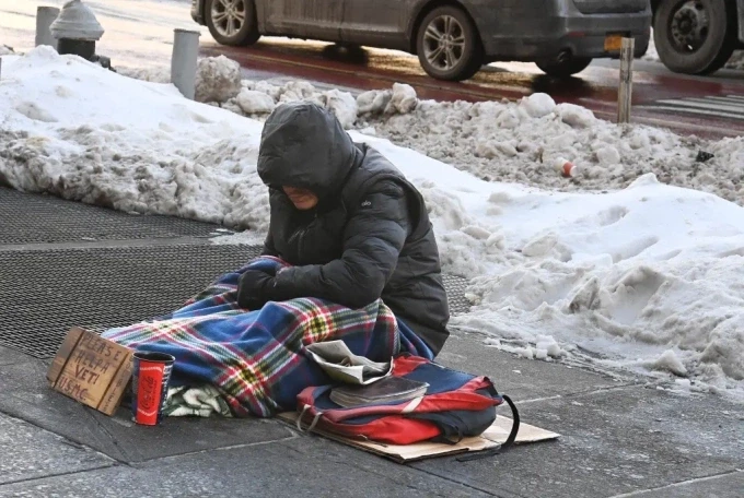 Một người vô gia cư ăn xin ở Union Square, New York, ngày 28/1. Ảnh: NYP