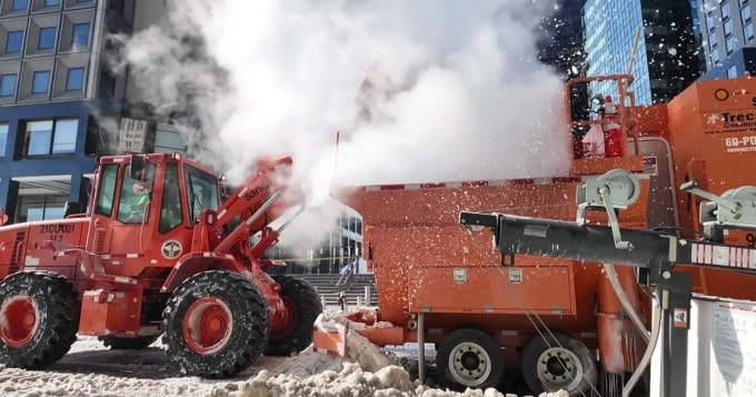 Máy xúc đổ tuyết vào thiết bị đun chảy trên đường phố New York ngày 28/1. Ảnh: CBS