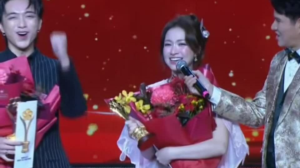 Hòa Minzy nâng cúp giải thưởng cạnh bố mẹ