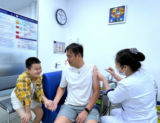 Bố cùng con trai tiêm vaccine HPV phòng bệnh tại VNVC Điện Biên Phủ, TP HCM. Ảnh: Diệu Thuần