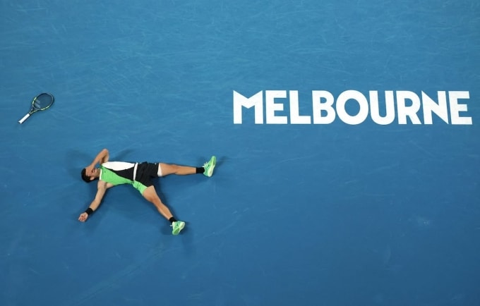 Carlos Alcaraz buông vợt, nằm ngửa ra sân khi vô địch Australia Mở rộng trên sân Rod Laver, thành phố Melbourne, bang Victoria, Australia tối 2/1/2026. Ảnh: Reuters