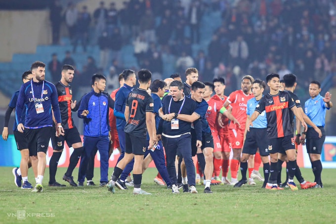 HLV thủ môn Đinh Xuân Việt ôm HLV CLB Ninh Bình Albadalejo (giữa), người đang nổi giận với trọng tài Razlan Joffri (phải) sau trận thua Công an Hà Nội 2-3 ở vòng 12 V-League 2025-2026, trên sân Hàng Đẫy ở Hà Nội ngày 1/2/2026. Ảnh: Hoàng Huynh