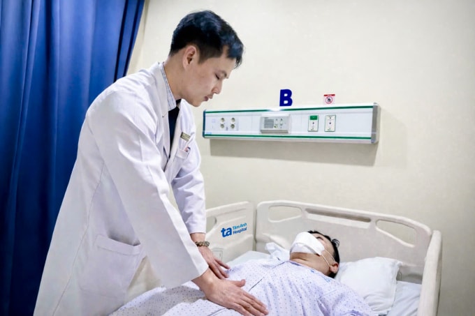 Bác sĩ Duy đang khám bụng cho ông Park sau phẫu thuật. Ảnh: Bệnh viện Đa khoa Tâm Anh