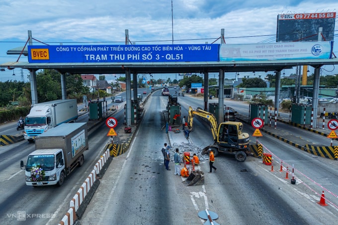 Xe cơ giới tiến hành tháo dỡ các dải bêtông ở làn thu phí. Ảnh: Trường Hà