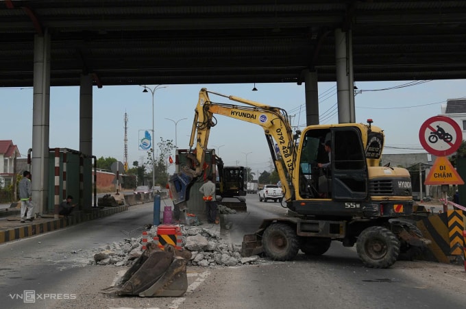 Xe cơ giới tiến hành tháo dỡ các dải bêtông ở làn thu phí. Ảnh: Trường Hà