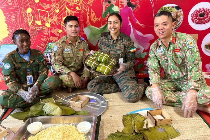 Lực lượng gìn giữ hòa bình Việt Nam hướng dẫn sĩ quan Ấn Độ, Zambia làm bánh chưng. Ảnh: Hải Yến