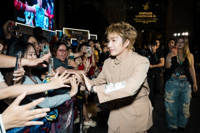 Ca sĩ Cody Nam Võ đập tay cùng fan khi xuất hiện ở thảm xanh. Ảnh: DatVietVAC