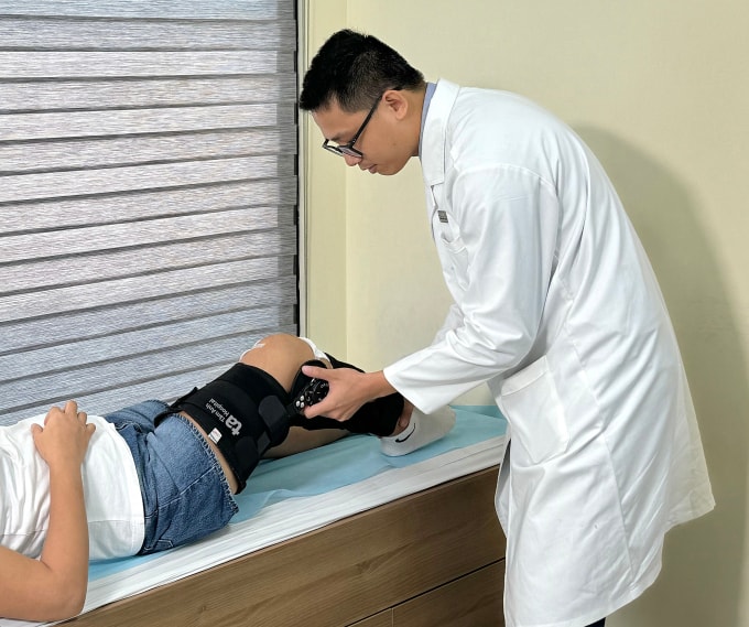 Bác sĩ Tân kiểm tra tình trạng vận động khớp gối của người bệnh sau phẫu thuật. Ảnh: Bệnh viện Đa khoa Tâm Anh