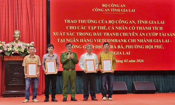 Thứ trưởng Bộ Công an - Thượng tướng Nguyễn Văn Long (giữa) trao thư khen cho các cá nhân đóng góp vào quá trình phá án, trưa 6/2. Ảnh: Ngọc Oanh