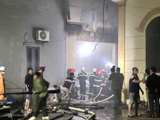 Cảnh sát tiếp cận đám cháy từ cửa sau sát nhà văn hóa. Ảnh: Gia Chính