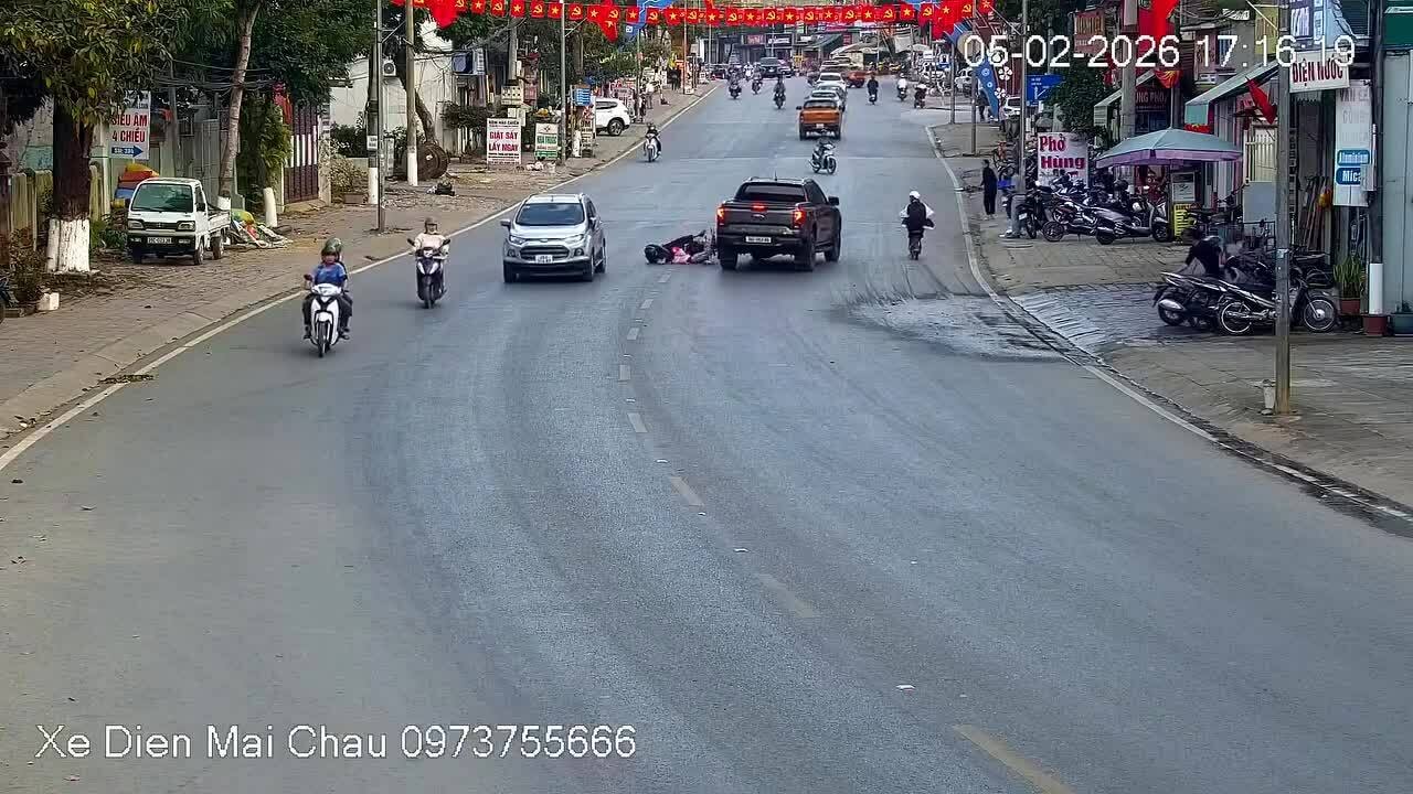 Người phụ nữ chở em bé ngã giữa hai ôtô 