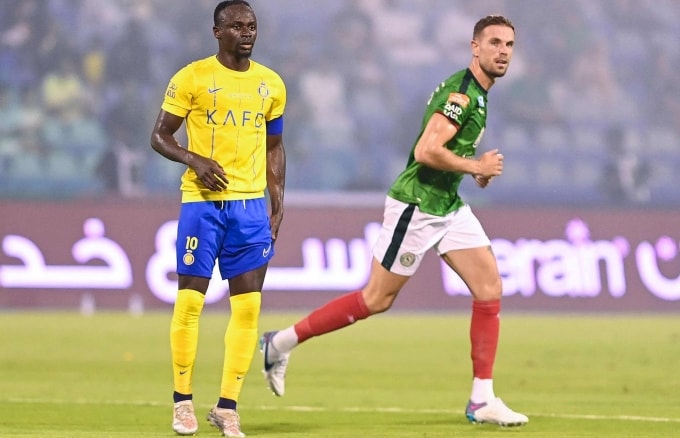 Henderson (áo xanh) thời còn chơi cho Al-Ettifaq, trước khi rời Arab Saudi trở lại châu Âu lần lượt khoác áo Ajax rồi Brentford. Ảnh: AFP