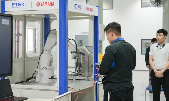 Đại diện một đội thi trình diễn giải pháp với cánh tay robot. Ảnh: ETEK