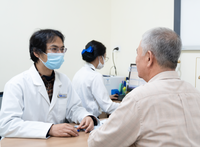Bác sĩ Tiến hỏi thăm các triệu chứng của ông Bình trong lần tái khám. Ảnh: Bệnh viện Đa khoa Tâm Anh