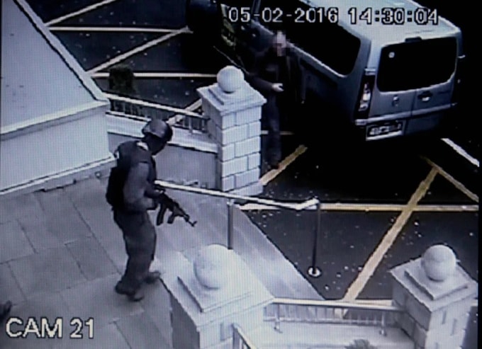 Tay súng cải trang thành cảnh sát cầm AK47 tẩu thoát khỏi khách sạn. Ảnh: Sun