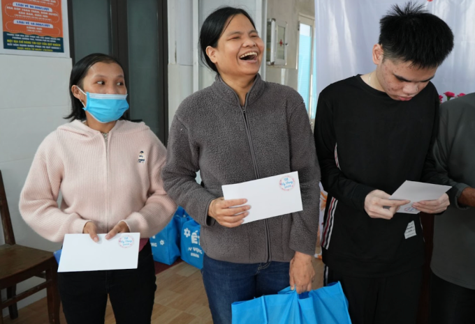 Chị Trương Thị Bích Diễm (ở giữa), 44 tuổi, tươi cười khi nhận quà từ chương trình Tết Hy Vọng.