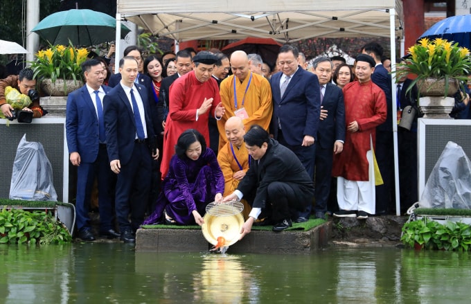 Chủ tịch nước Lương Cường và phu nhân thực hiện nghi thức thả cá chép tại hồ Hoàn Kiếm, sáng 8/2. Ảnh: Hoàng Phong