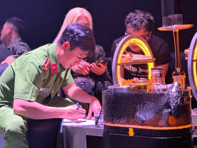 Cảnh sát lập biên bản các dấu hiệu vi phạm pháp luật xảy ra tại bar Aplus, rạng sáng nay. Ảnh: Công an TP HCM