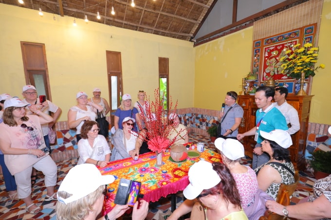 Du khách tìm hiểu về tục thờ cúng của người Việt và cách bày trí bàn thờ ngày Tết của người miền Tây.